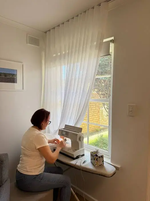 Custom linen curtain adjustment carried out on site beside the window
