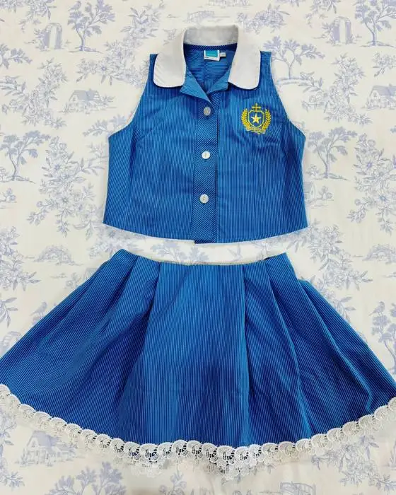Blue school uniform remodelled into a sleeveless top and lace-trimmed pleated skirt